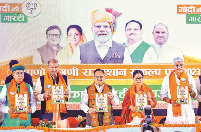 Party state president CP Joshi, Vasundhara Raje, Union Minister Gajendra Singh Shekhawat and Arjun Ram Meghwal can be seen releasing the JP Nadda manifesto. Photo: PTI