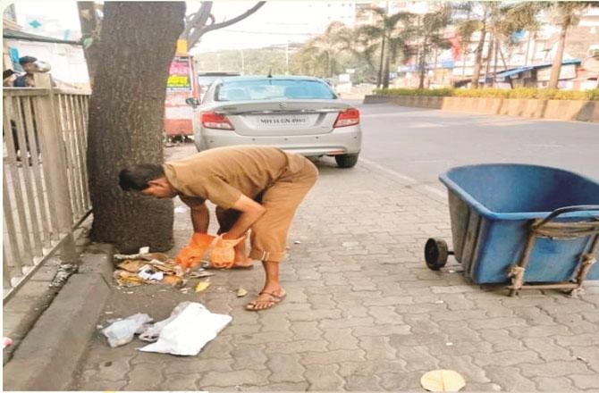 An employee of the Municipal Corporation is cleaning the garbage.