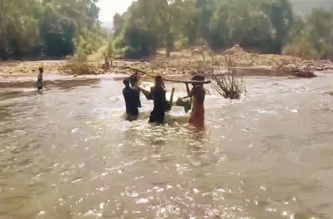 People of the village crossing the river with the corpse. Photo: Social Media