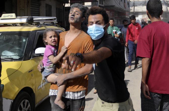 A man carries a victim to safety after an Israeli attack in Khan Yunis. Photo: PTI