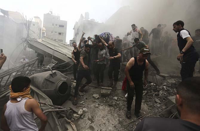 Palestinians pulling one of their comrades out of the rubble. Photo: PTI