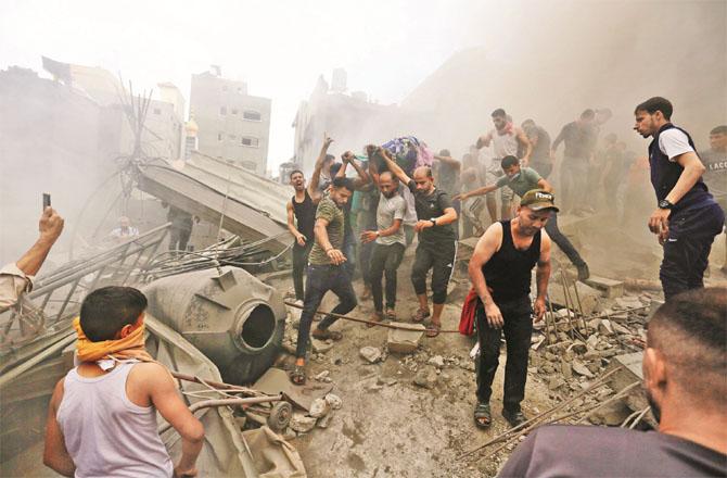 After the bombardment of Gaza, young people pull out dead bodies and wounded from the rubble. Photo: AP/PTI