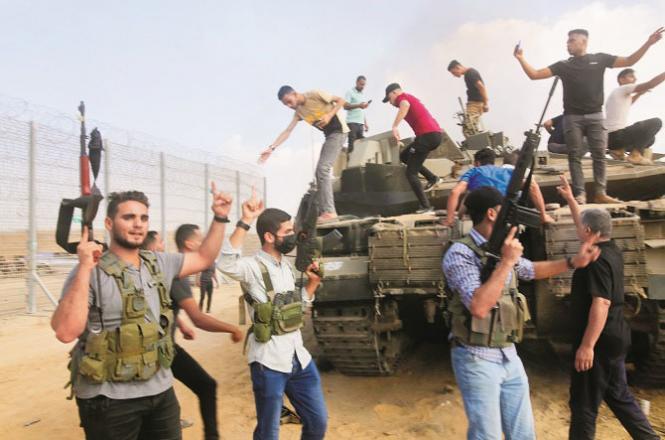 Hamas fighters can be seen celebrating after capturing an Israeli tank. Photo: AP/PTI