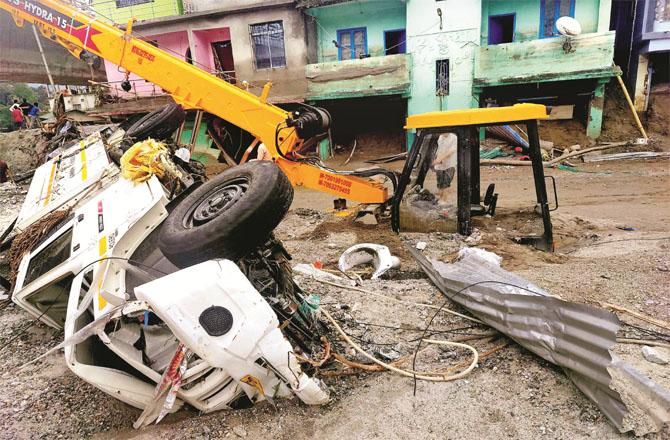 A wrecked vehicle and JCB after floods in Sikkim. Photo: PTI