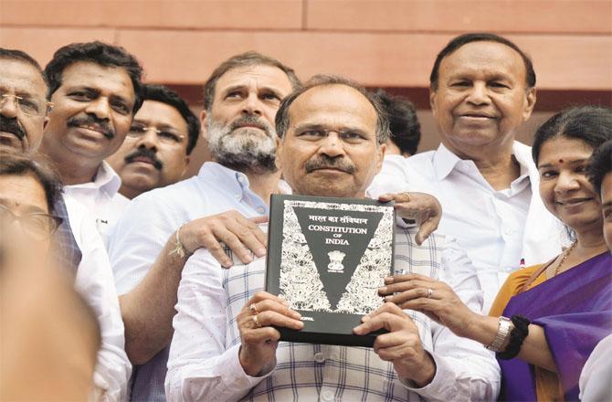 Adhir Ranjan Chowdhury along with Rahul Gandhi and other opposition leaders showing the copy of the constitution which has been provided by the government. (PTI)