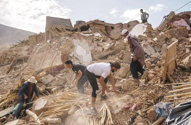 A family can be seen outside their damaged home. Photo: PTI