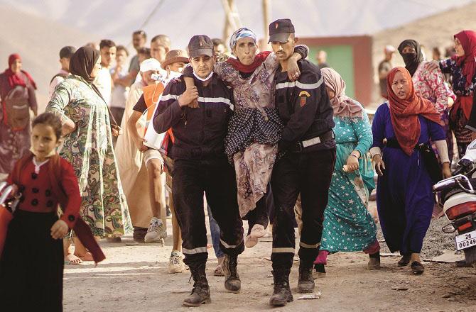 Attempting to evacuate a woman from an earthquake-hit area. Photo: AP/PTI