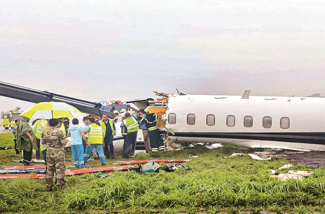 After the accident, security and rescue personnel are gathered around the wrecked plane. (PTI)