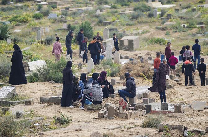 On Eid, Palestinians can be seen at the graves of their loved ones. Photo: PTI