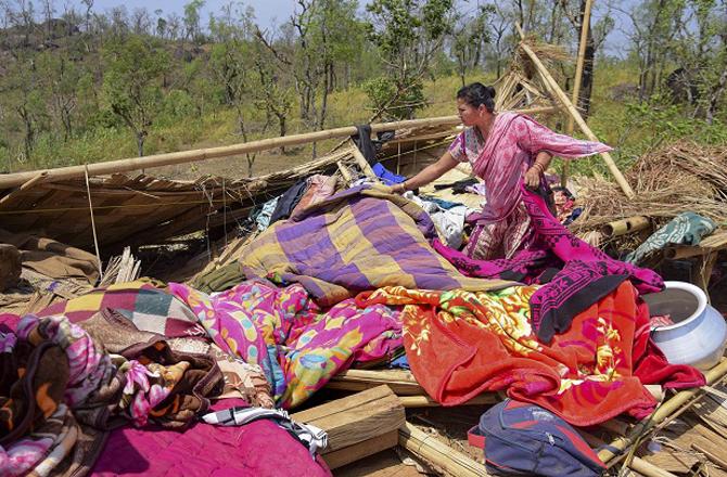 A woman removing belongings from her broken house. Photo: PTI