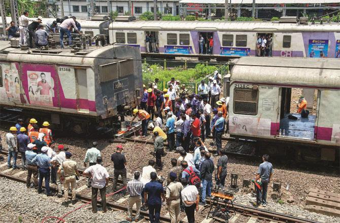 Railway employees can be seen trying to get the coach on the track. Photo: PTI