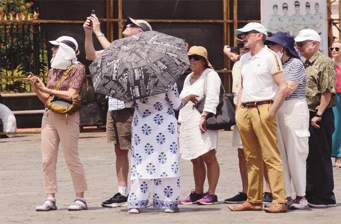 Citizens are using umbrellas and caps to avoid the hot sun. Photo: Syed Sameer Abidi