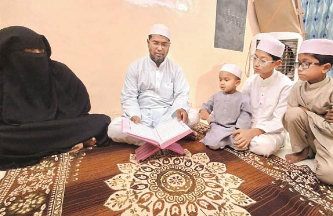 Hafiz Hilal Ahmad reciting while his wife Hafiza Ayesha Parveen and children can also be seen in close proximity. Photo: INN