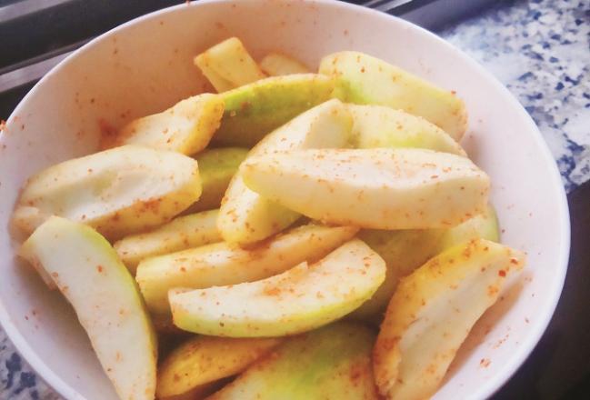 The raw mango, called `Takura` in the village, is peeled and sprinkled with salt and pepper. Photo: INN