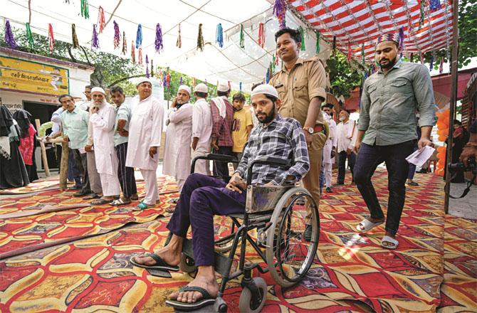 A large number of Muslim voters reached the polling booth in Meerut. Here the police also helped the disabled voters. Photo: PTI
