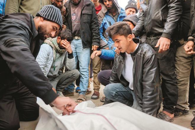 A boy paying his last respects to his deceased loved one in Khan Younis camp. Image: INN