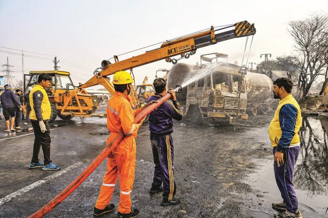 Fire brigade employees putting out the fire at the accident site. Photo: PTI