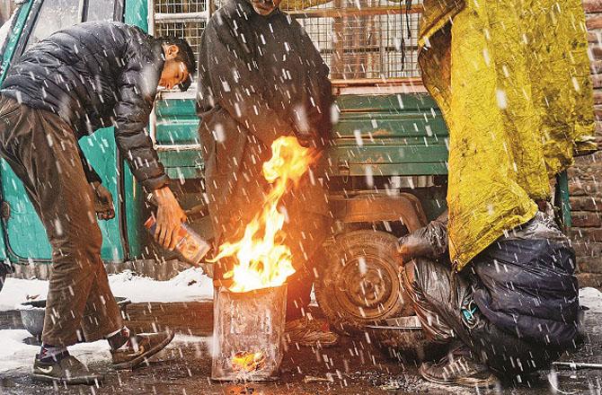 People fire during first snowfall in Srinagar. Photo: PTI