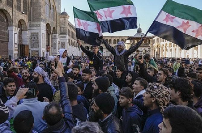 People celebrate after the fall of Bashar al-Assad`s regime. Photo: PTI