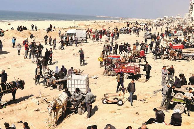 People are waiting for humanitarian aid on the shores of Gaza City. Photo: AP/PTI