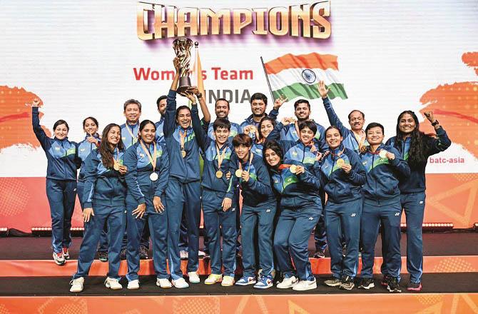 India`s badminton team looks on with the trophy. Photo: INN