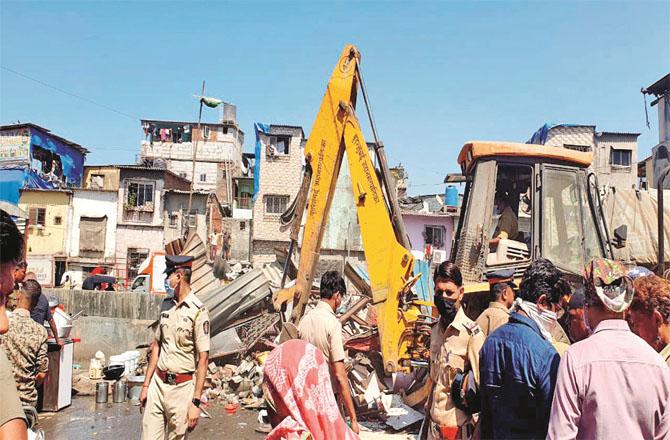 Demolition squads removing illegal encroachments in Maloney. Police officers are also seen.Photo: Inquilab