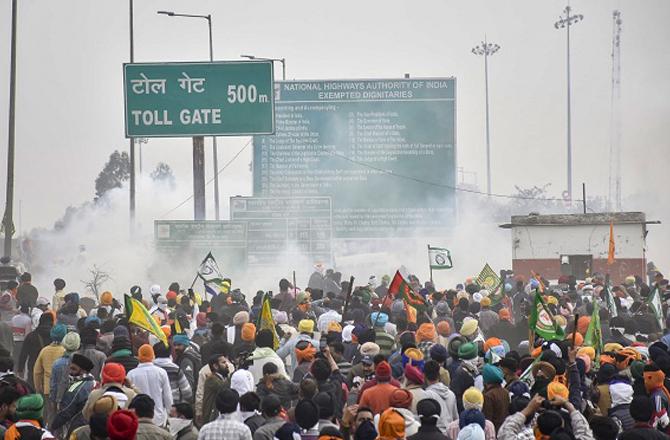 Protesters retreat after firing tear gas shells. Photo: PTI
