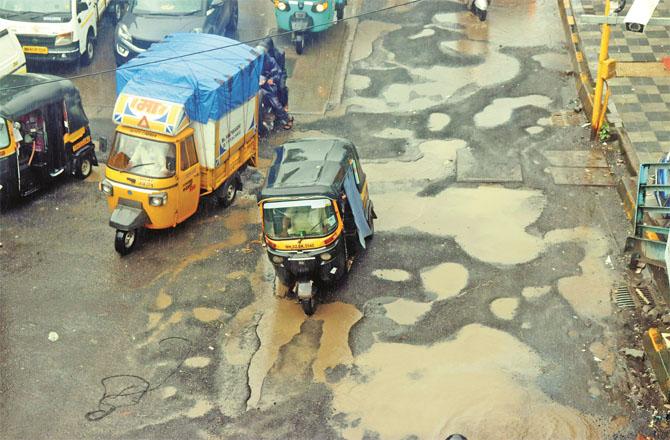 Potholes are seen on a road in Goregaon. Photo: Inquilab ,Anurag Ahire