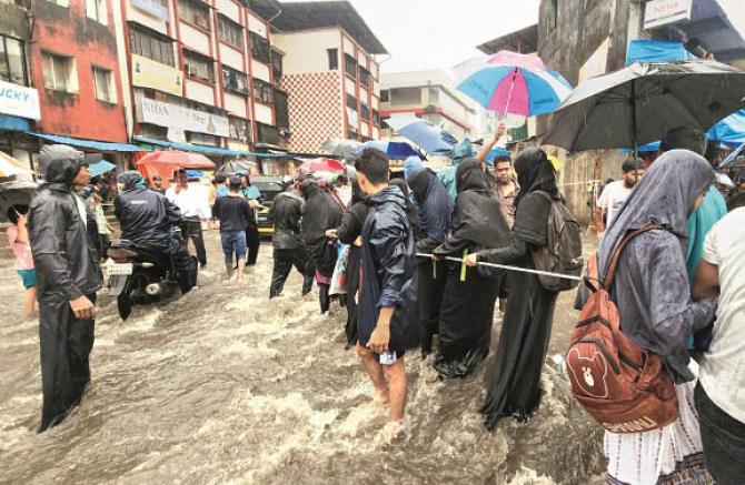 People are walking through a submerged road. Image: Revolution