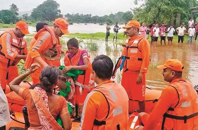 The NDRF team is evacuating local people stuck in the flood situation at Pal Ghar by boat. Photo: INN