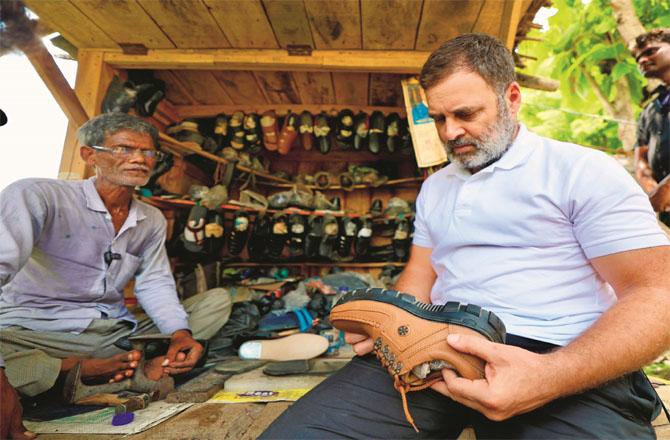 Rahul Gandhi looking at a shoe at Mochi Chet Ram`s shop. Photo: INN
