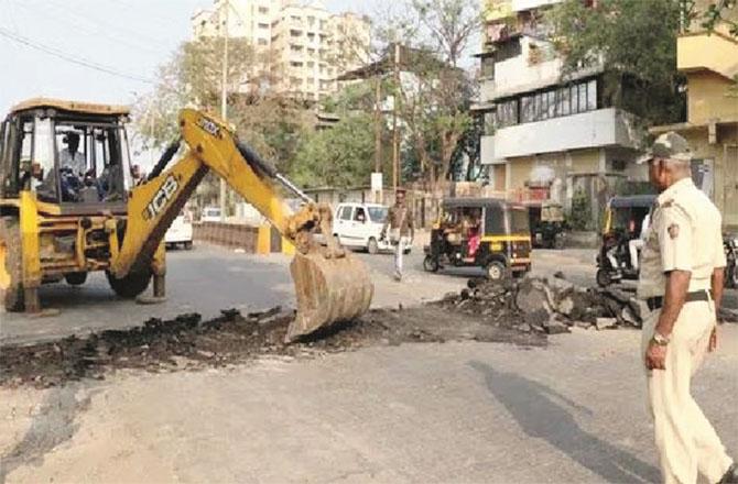 Traffic police with the help of BMC removing a road speed breaker.