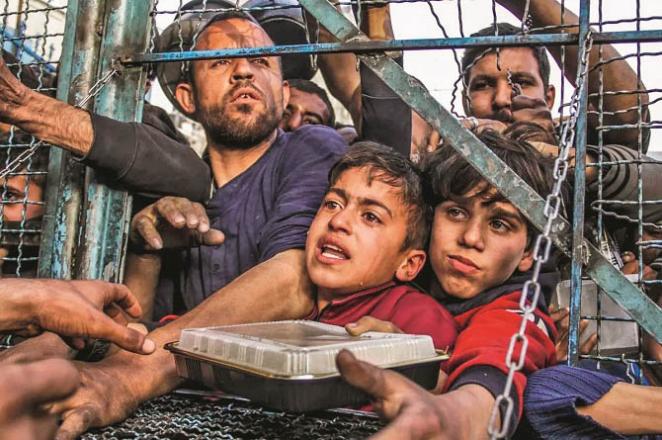 Starving children receiving food packets at a food distribution center. Image courtesy: Anadolu