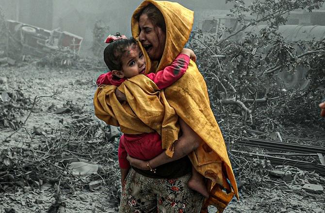 A Palestinian mother protects her child from Israeli attacks. Photo: X