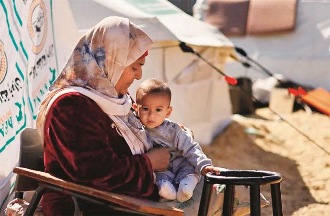 A Palestinian mother with her baby girl. Photo: INN