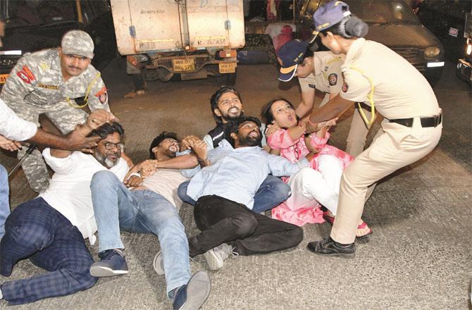 Police personnel are detaining the protesting Aam Aadmi Party workers. Photo: PTI