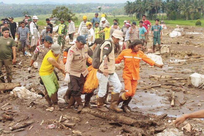 A rescue team carrying a dead body in West Sumatra. Photo: AP/PTI