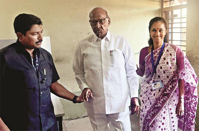 Baramati candidate Supriya Slay with her father Sharad Pawar at the polling booth. Photo: PTI