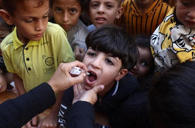 A doctor administers polio drops to a Palestinian child in Khan Yunis, Gaza. Photo: INN.