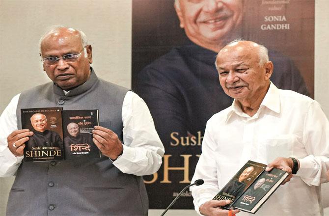 Sushil Kumar Shinde and Mallikarjan Kharge, with book