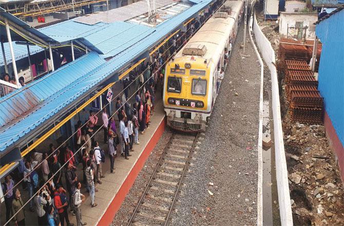 Passengers are waiting for the train to stop at the newly built platform at Malad station