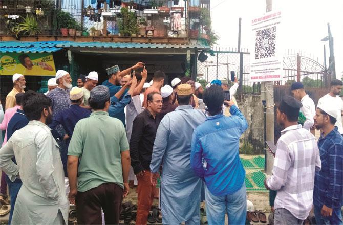 Worshipers scan a QR code outside Mahada Maloney`s Chhoti Tayyaba Mosque