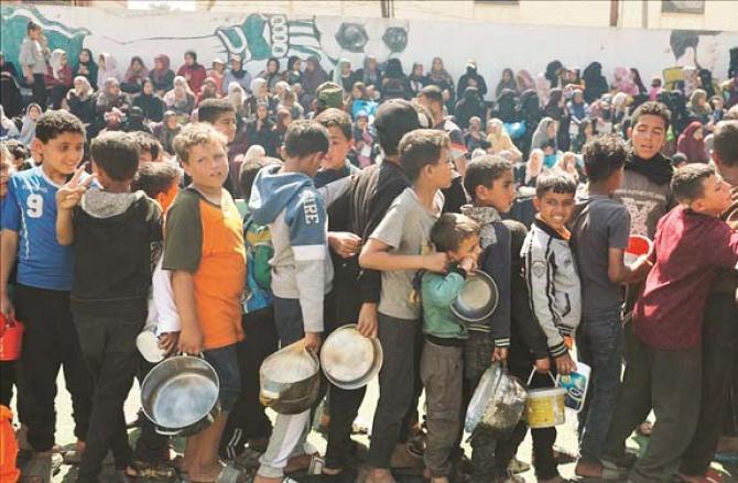 Children queue to get food at a center in Gaza. Photo: INN