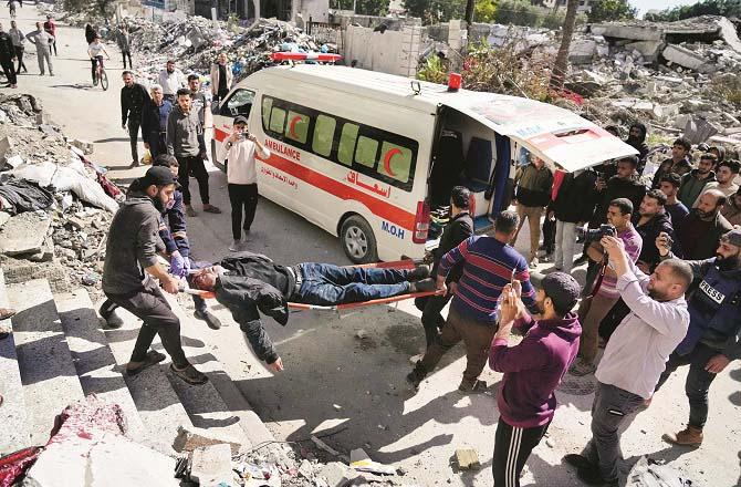 A man injured in an Israeli attack in Gaza is carried away in an ambulance. Photo: INN