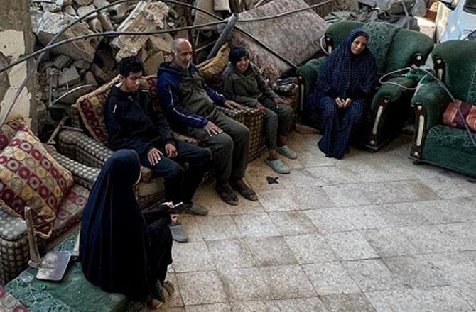 A family in Gaza sits in their war-torn home. Photo: INN.