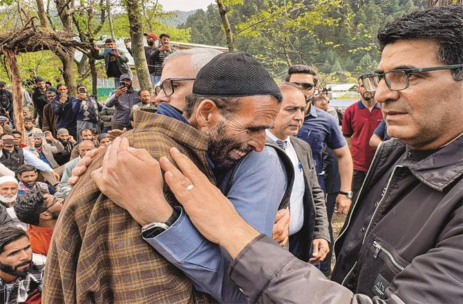 Kashmir Chief Minister Omar Abdullah consoles the father of Syed Adil Hussain Shah (left).