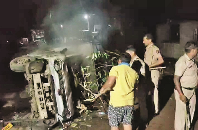 Police officers extinguish a car fire on Friday night. Photo: INN