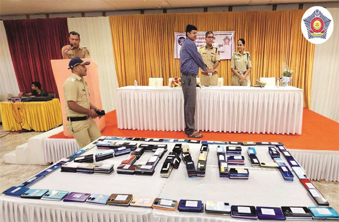 Recovered mobile phones while a police officer returns a person`s mobile phone.
