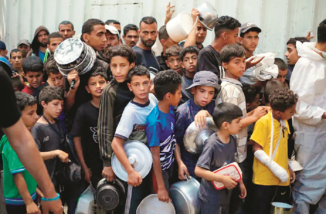 People, mostly children, are seen queuing to receive aid in Gaza. Photo: INN.