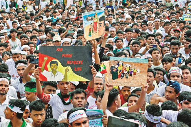 Muhammad Yunus visited the Katupalong camp. Left: Participants display posters at the eighth anniversary event in the open field of the refugee camp. Photo: INN